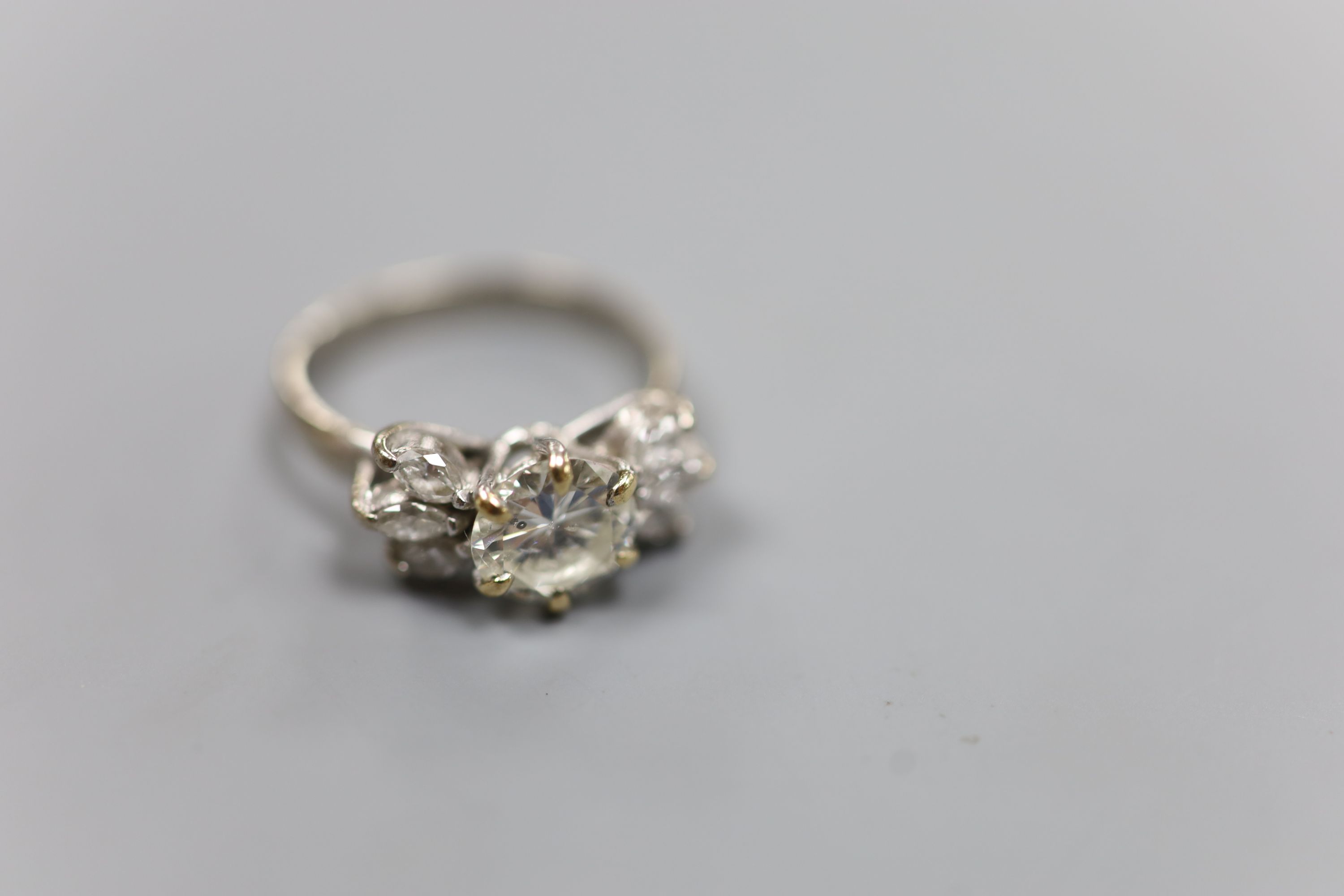 A white metal (stamped 18ct Plat) and single stone diamond ring, with six stone marquise cut diamond set shoulders, size K